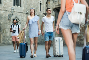 Joyful couple in shorts with luggage