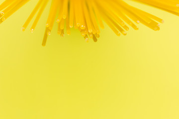 long yellow spaghetti pasta on yellow background. Yellow Italian pasta. Italian food and kitchen concept. copy space 