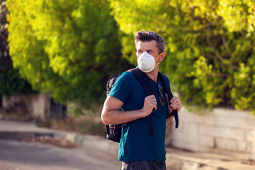 Fototapeta premium A portrait of man with medical face mask outdoor. Virus protection concept