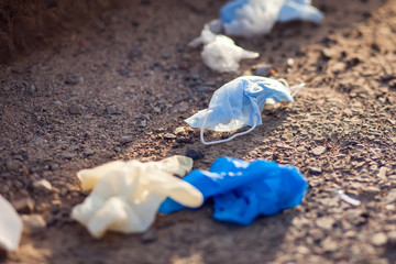 Used medical masks and gloves on ground on the street. Environmental pollution concept