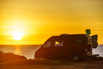Camper van on beach at sunrise