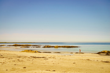 Woman walking on sandy beach, Lofoten Norway