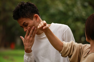 女性に殴られる男性