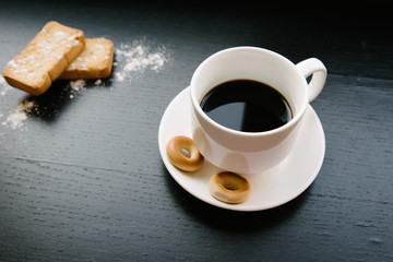 Simple set up for morniing coffee break which includes coffee cup and saucer and few bagels and...