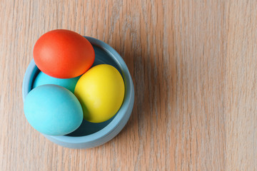 Fototapeta na wymiar Colorful Easter eggs in a blue bowl. Easter eggs are a symbol and a mandatory attribute of Easter.