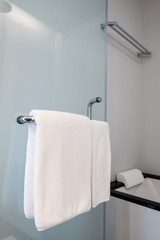 Obraz na płótnie Canvas White towels hanging at the bathroom rail.