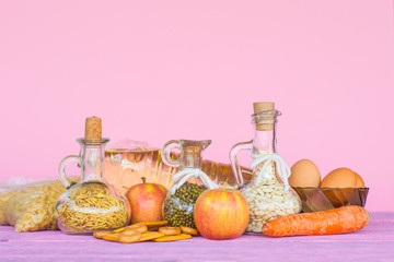 A set of food supplies on a pink background. The concept of food.