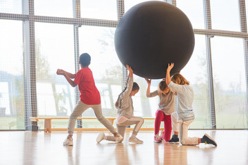 Children play with an oversized ball
