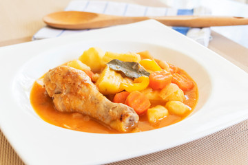 close up of chicken stew with tomatoes, potatoes, carrot, thym, and ketchup.
