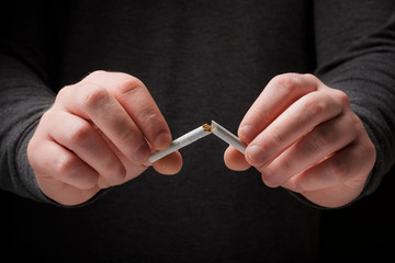 Male hands breaking a cigarette. Stop smoking cigarettes concept. Quit bad habit, healthy lifestyle...