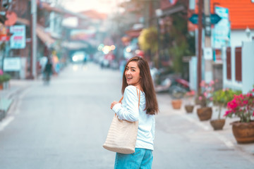 Fototapeta premium smile happy girl in good morning time on the road with blur village by her wearing shirt white and jeans