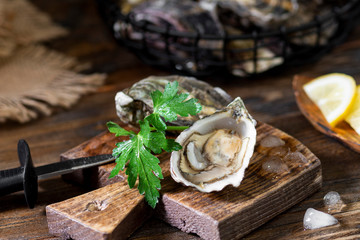 Two oysters on a wooden Board against the background of a basket of oysters