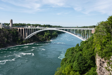 Fototapeta na wymiar Rainbow Bridge over river with blue sky, Niagara falls, USA and Canada Border