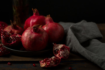 Ripe pomegranates on dark moody table