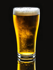 Pint of cold delicous draught beer on black background