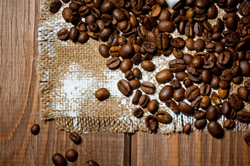Grains of black coffee lying on a rough canvas. Background for coffee drinks.