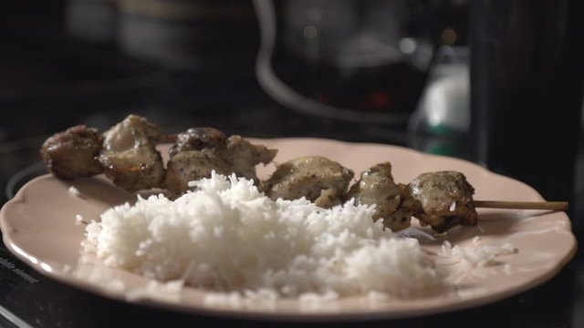 Hand Of A Man Putting Soysauce On His White Rice And Chicken Shish Kabob.-  closeup shot