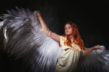 White angel on a dark background with colored lighting. The concept of war between good and evil....
