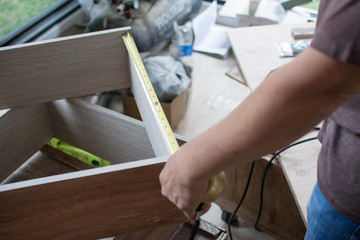 using tape measure for measuring size of wooden furniture