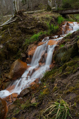 City Cesis, Latvia. Old waterfall with green moss and red rocks.