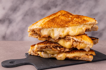 Four stacked servings of chicken and melted cheese sandwich