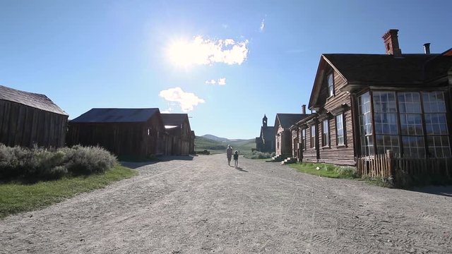 Mother and Son Walk the Streets as Family Tourists Visiting Old Historic Abandoned Mining Town Bodie California