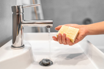 Corona virus washing hands with soap bar at home COVID-19 prevention. Hand hygiene for coronavirus...