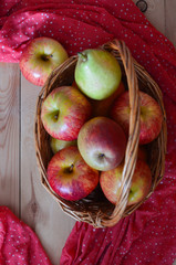 Fresh fruit top view on a wooden background. Straw basket with apples and pears. Autumn harvest in...