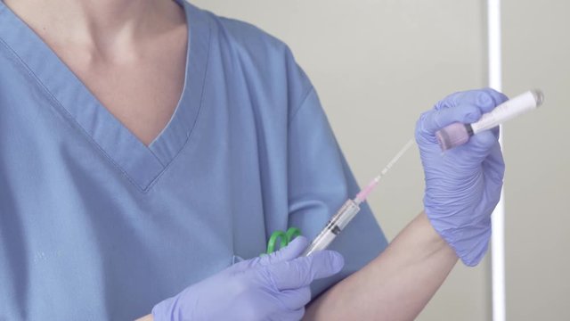 Nurse preparing Coronavirus Vaccine. Camera zoon in on transparent liquid vaccine