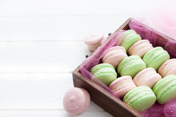 Colorful French macaroons , pink and green macaroons  on wooden board.