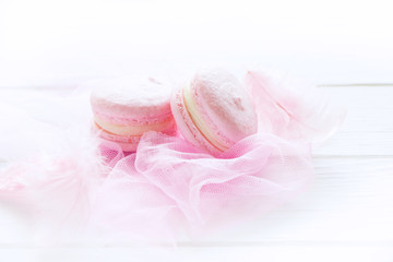 Pink macaroons on white wooden board. French cookies, sweets background