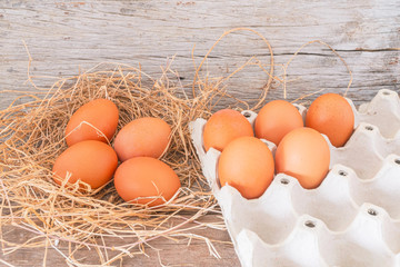 Close-up view of raw chicken eggs in egg box on wooden background., Fresh chicken eggs from the farm are laid out in panels and then on the wooden floor.