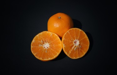 Juicy Mandarin Orange and Cuts Isolated on Black Background, Perfect for Wallpaper