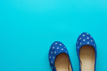Vintage blue pair of polka dot shoes on a blue background.