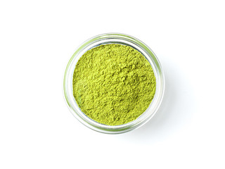 Green matcha tea powder in small glass bowl on white background. Powdered maccha tea, isolated on white with clipping path. Top view or flat lay. Copy space for text or design