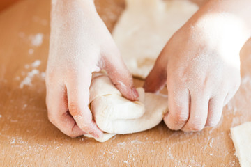 A girl and little sister are cooking pastries in the kitchen at the table, flour and rolling pin,...