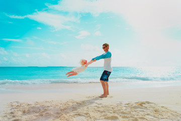 father and little daughter play at beach