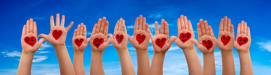 Many Children Hands Showing Red Heart Symbols And Smileys. Blue Sky Background