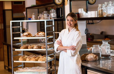 Portrait of young female baker standing at bakery.