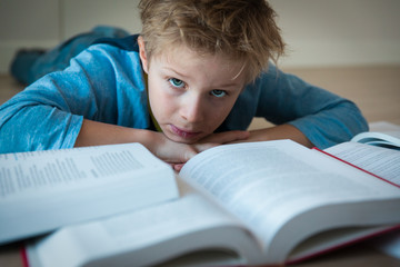 young boy tired of reading, kid having too much homework
