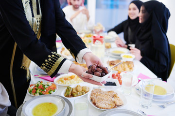 Muslim family having Iftar dinner eating dates to break feast
