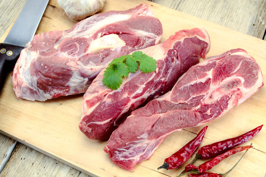 viande d'agneau cru sur une planche &agrave; d&eacute;couper