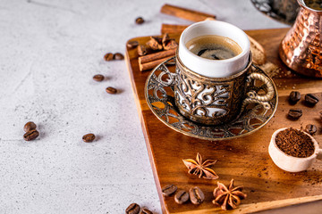 Oriental arabic style coffe cup with coffee beans and powder on a white table