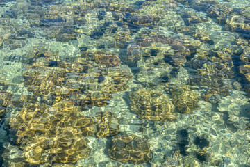 Natural background of crystal clear sea and coral site near Phuket island, Thailand. Rippled water...