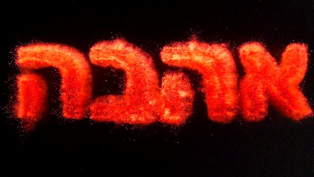 In real slow motion footage, the Hebrew word for love, אהבה (Ahava), is written in red powder and explodes like a firework brilliantly towards the camera. Top Shot.