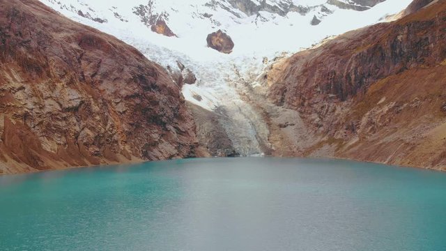arhuaycocha lake, reversal fly aerial shot in middle of the lake, peruvian andes, turistic treking.