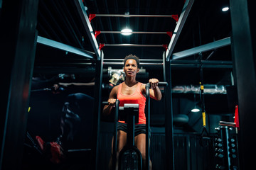 Naklejka na ściany i meble Fitness female using air bike for cardio workout at crossfit gym.