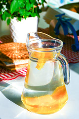 A pitcher of water filled with orange slices.