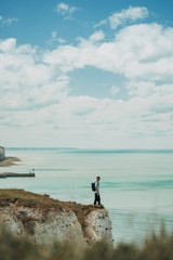 A man standing at the top of the cliff