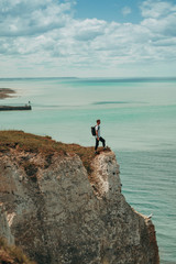 A man standing at the top of the cliff